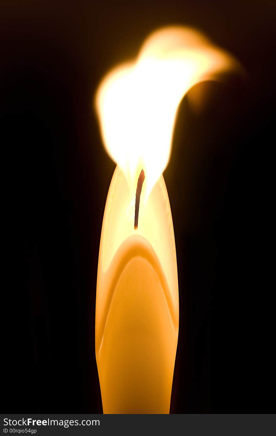 Burning candle isolated on black background