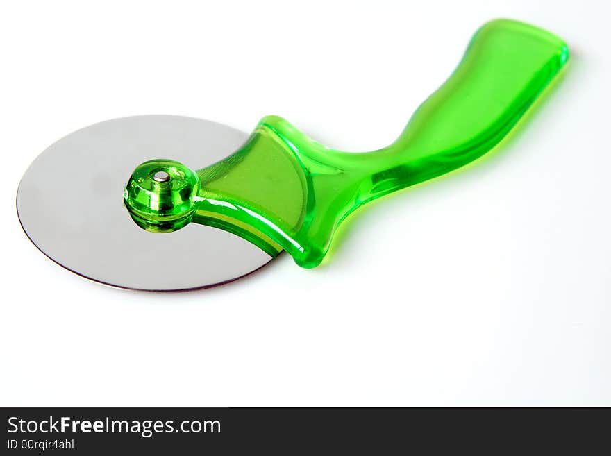 Green pizza cutter on a light background