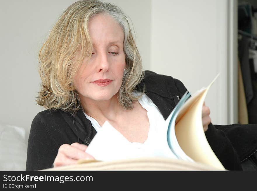 Businesswoman relaxing at home reading documents.