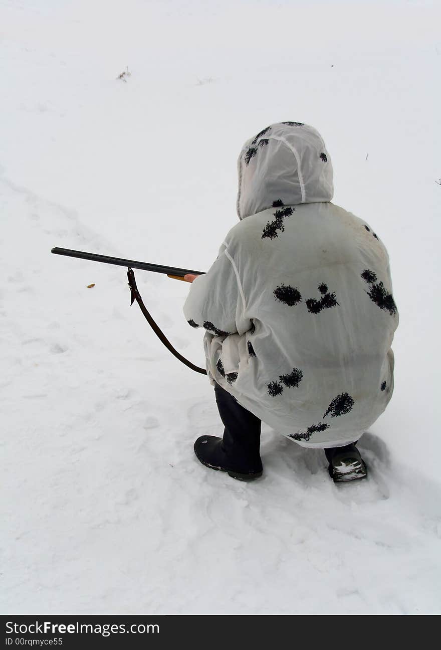 Hunter squatted down on snow. Hunter squatted down on snow