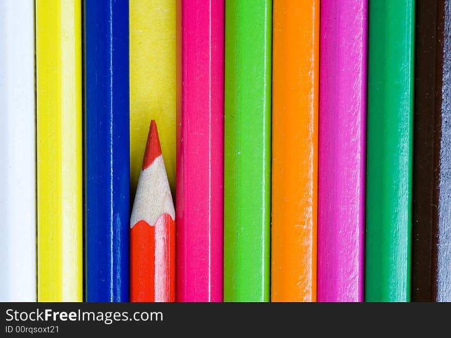 Red pencil crayon isolated from other colorful pencil crayons. Red pencil crayon isolated from other colorful pencil crayons