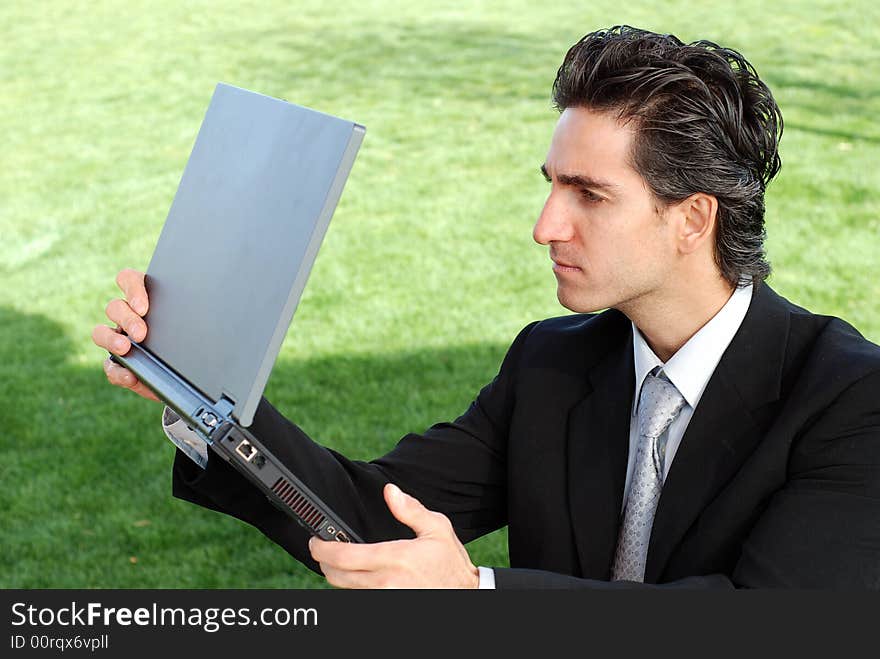 Confident and successful young adult businessman working on his laptop computer