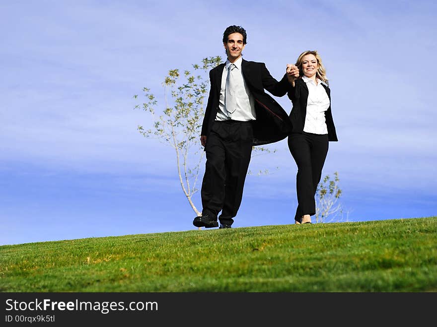 Portrait of a confident and successful business partners running in the field. Portrait of a confident and successful business partners running in the field