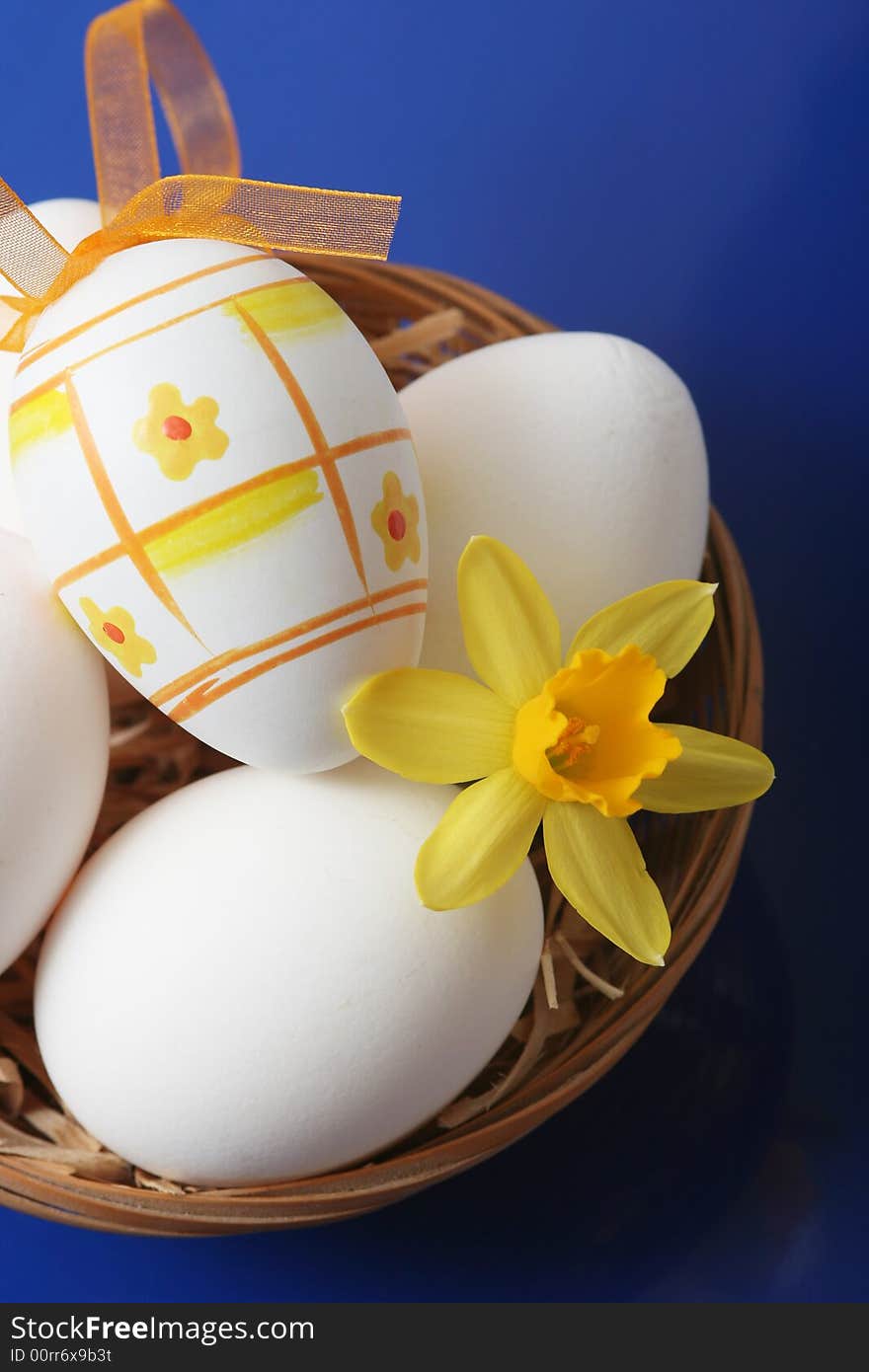 Easter eggs with yellow flower on blue background.