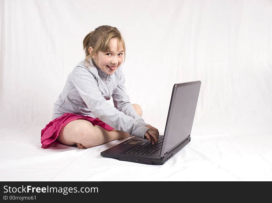 Checky young girl playing on laptop