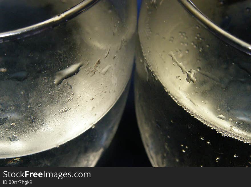 Close-up of two champagne glasses filled with bubbly on a blue background. Close-up of two champagne glasses filled with bubbly on a blue background