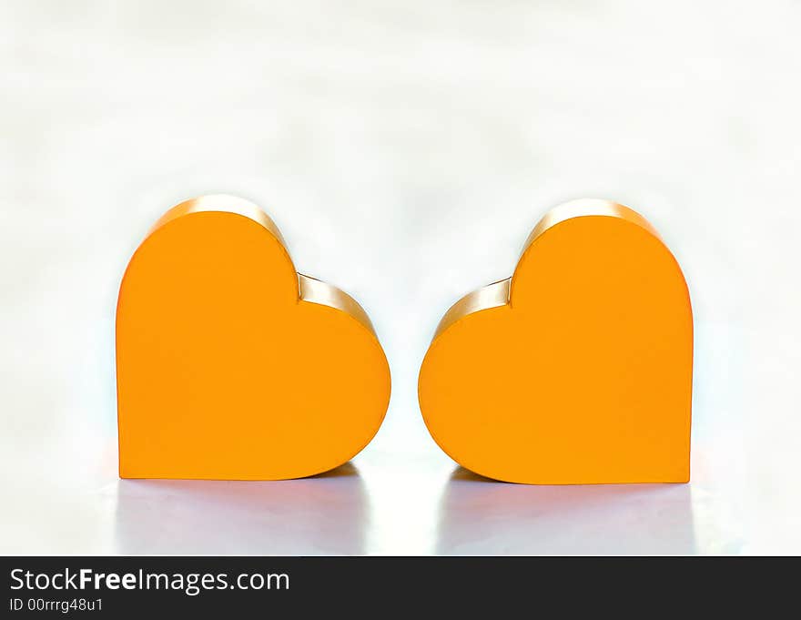 Two yellow hearts over white background