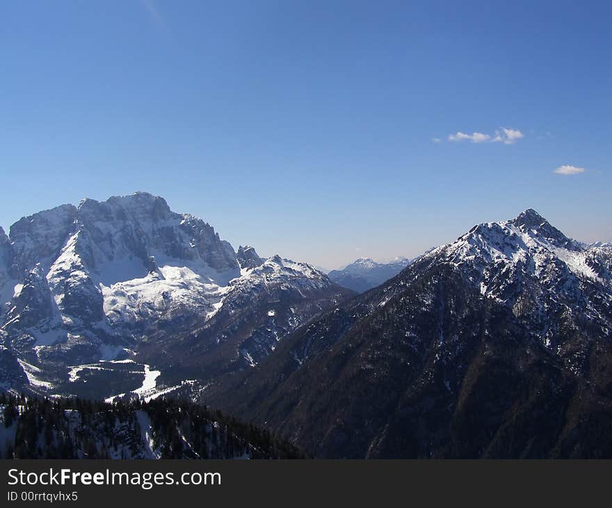 Winter in the Alps, beautiful alpine peaks and forests covered in snow on a beautiful sunny day