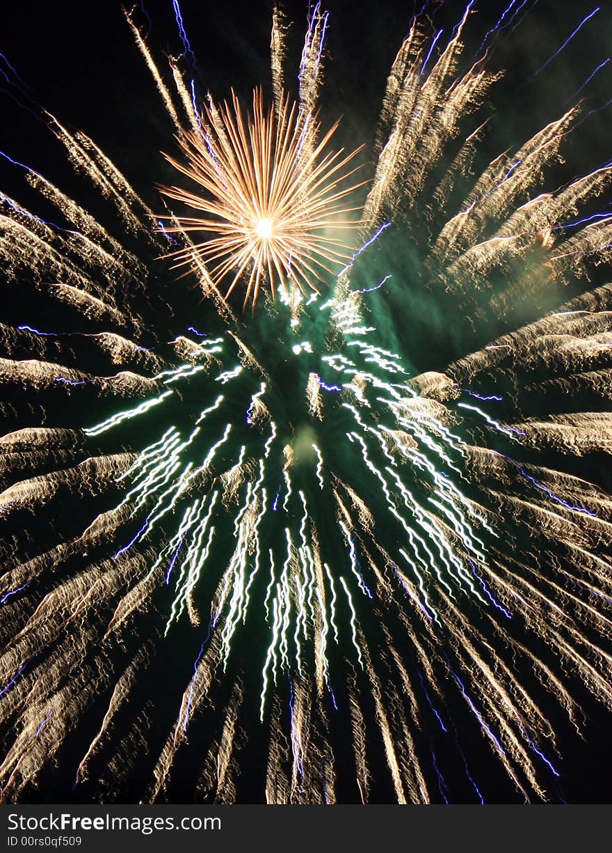 Gold green and blue fireworks in black sky