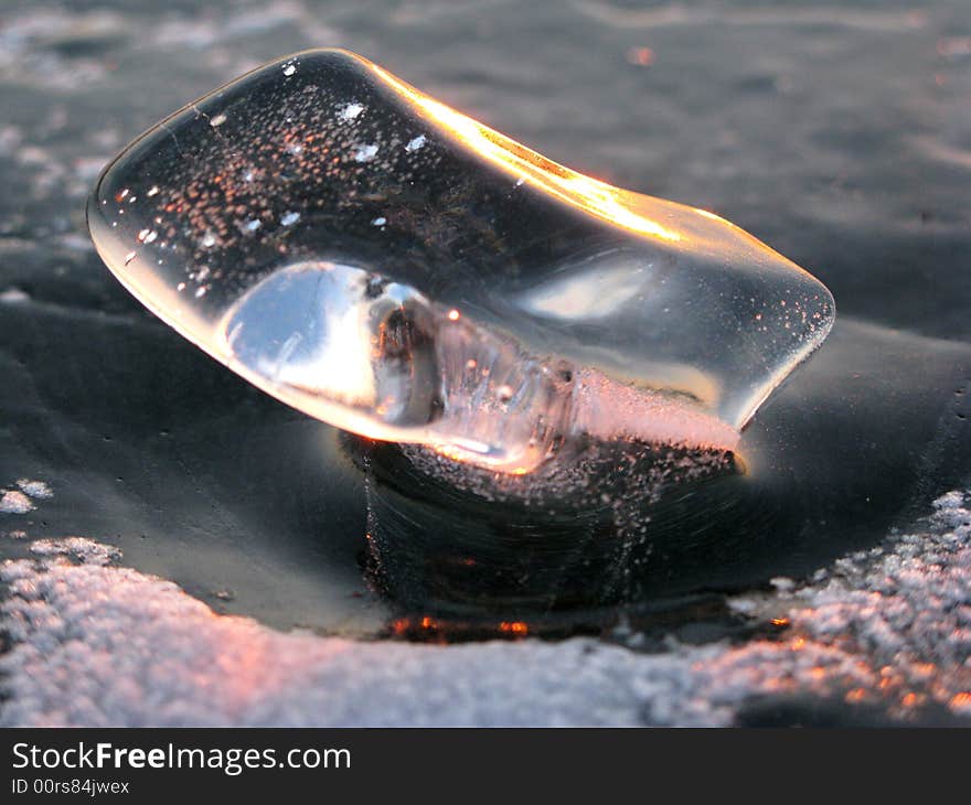 Translucent ice bit collects and reflects sunset light. Translucent ice bit collects and reflects sunset light