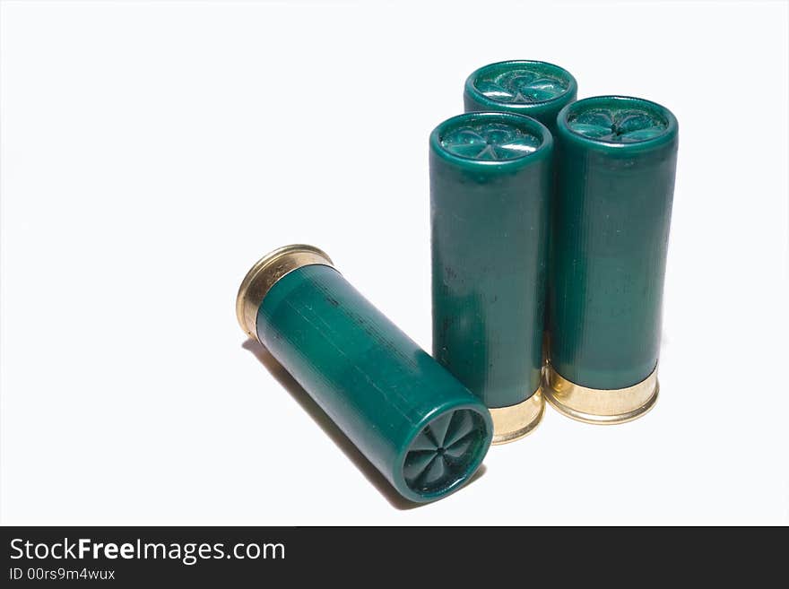 3 shot gun cartridges standing up side by side one lying down. 3 shot gun cartridges standing up side by side one lying down