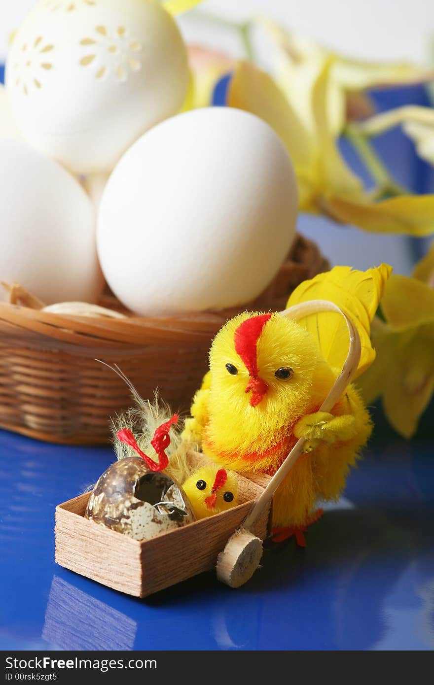 Easter motive.Hen and her chick,white eggs on blue background.