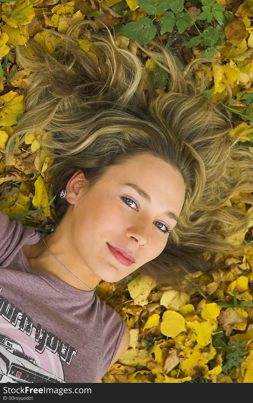 The beautiful girl lays in autumn leaves. The beautiful girl lays in autumn leaves