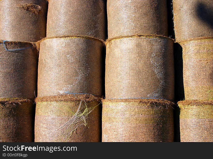 A stack of harvested straw bales in a farmers field photographed in close crop. A stack of harvested straw bales in a farmers field photographed in close crop