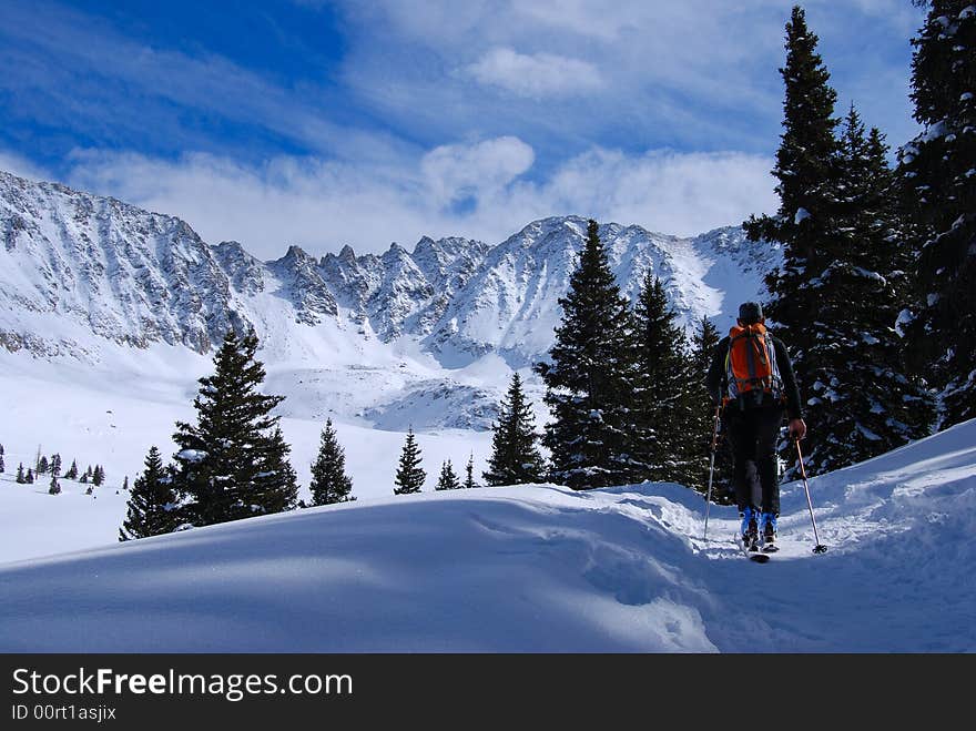 Skier skinning along trail to the peaks at the back of mayflower gulch