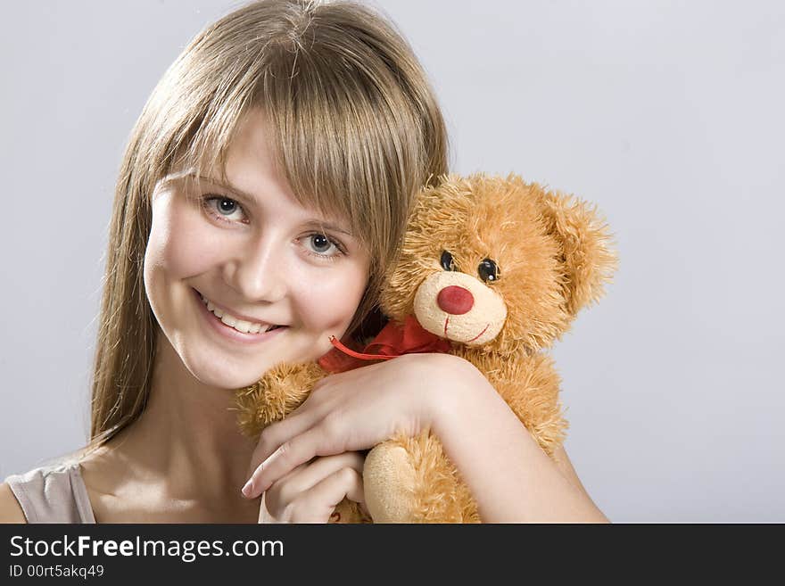 Smiling teen holding a teddy bear toy