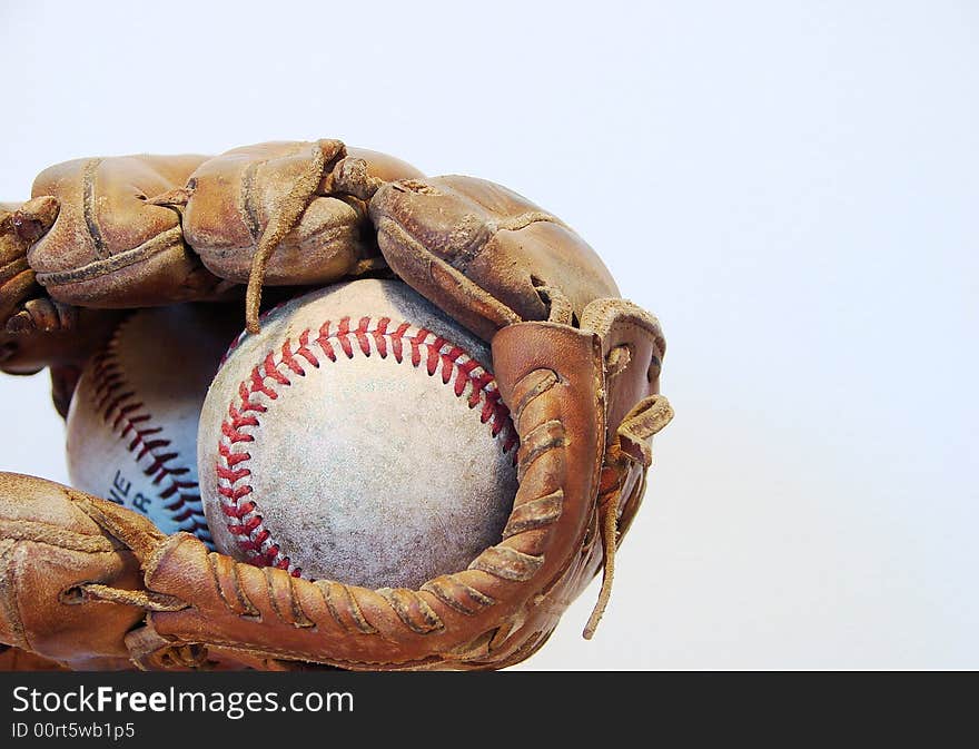 A worn baseball mitt and ball isolated on white. A worn baseball mitt and ball isolated on white