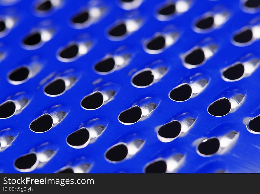 Close up of a stainless steel grater with blue reflection. Close up of a stainless steel grater with blue reflection