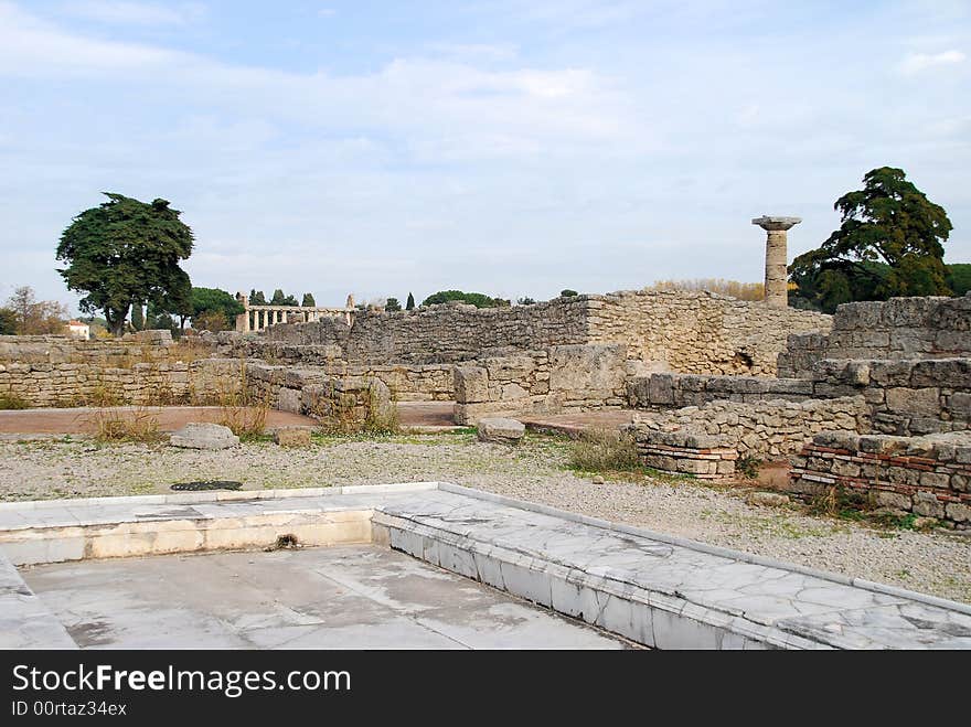 Ruins of the Roman town around the ancient Greek temples at Paestum in Italy. Temple is in the background. Ruins of the Roman town around the ancient Greek temples at Paestum in Italy. Temple is in the background.