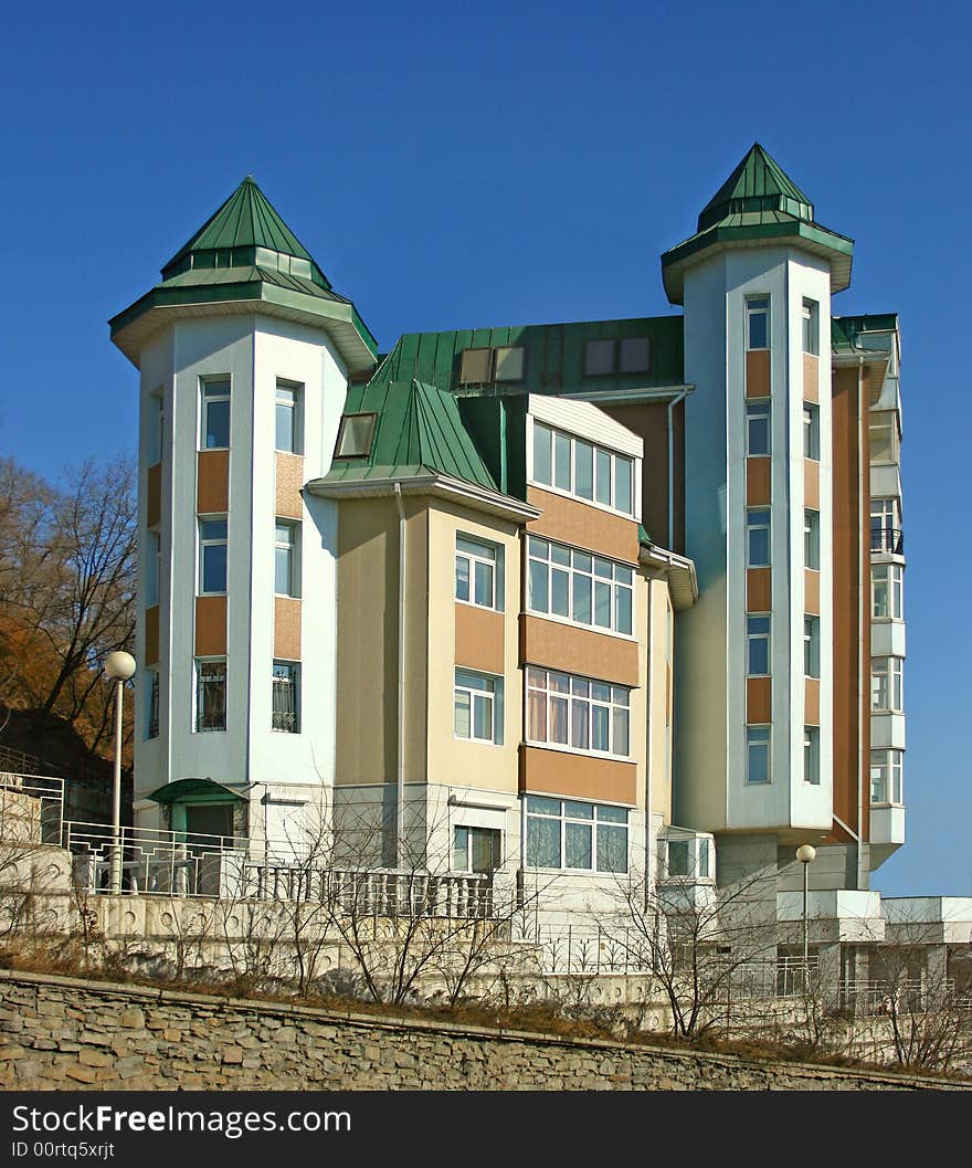 Modern house with  two tower and green housetop, fall