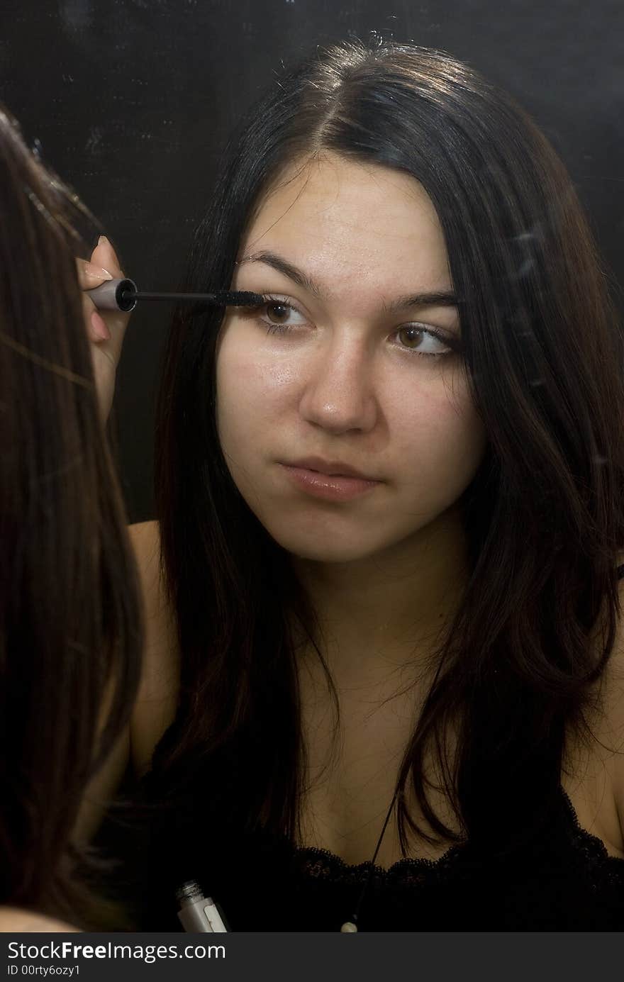 Young girl putting on her makeup. Young girl putting on her makeup