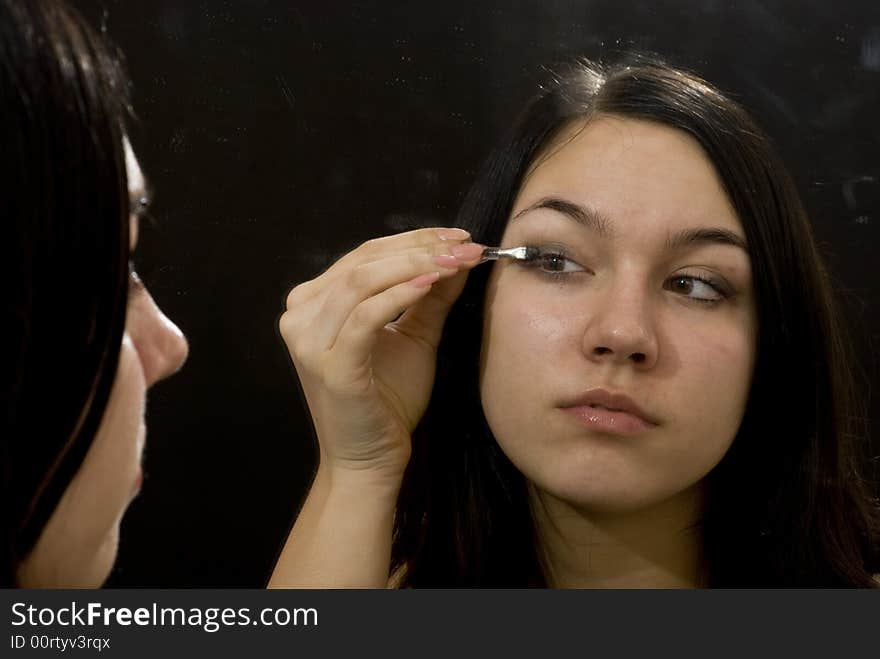 Girl putting on her makeup. Girl putting on her makeup