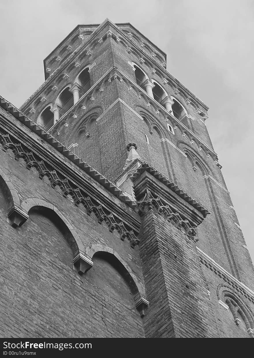 Religion and architecture: looking up view of a brick church tower in black and white