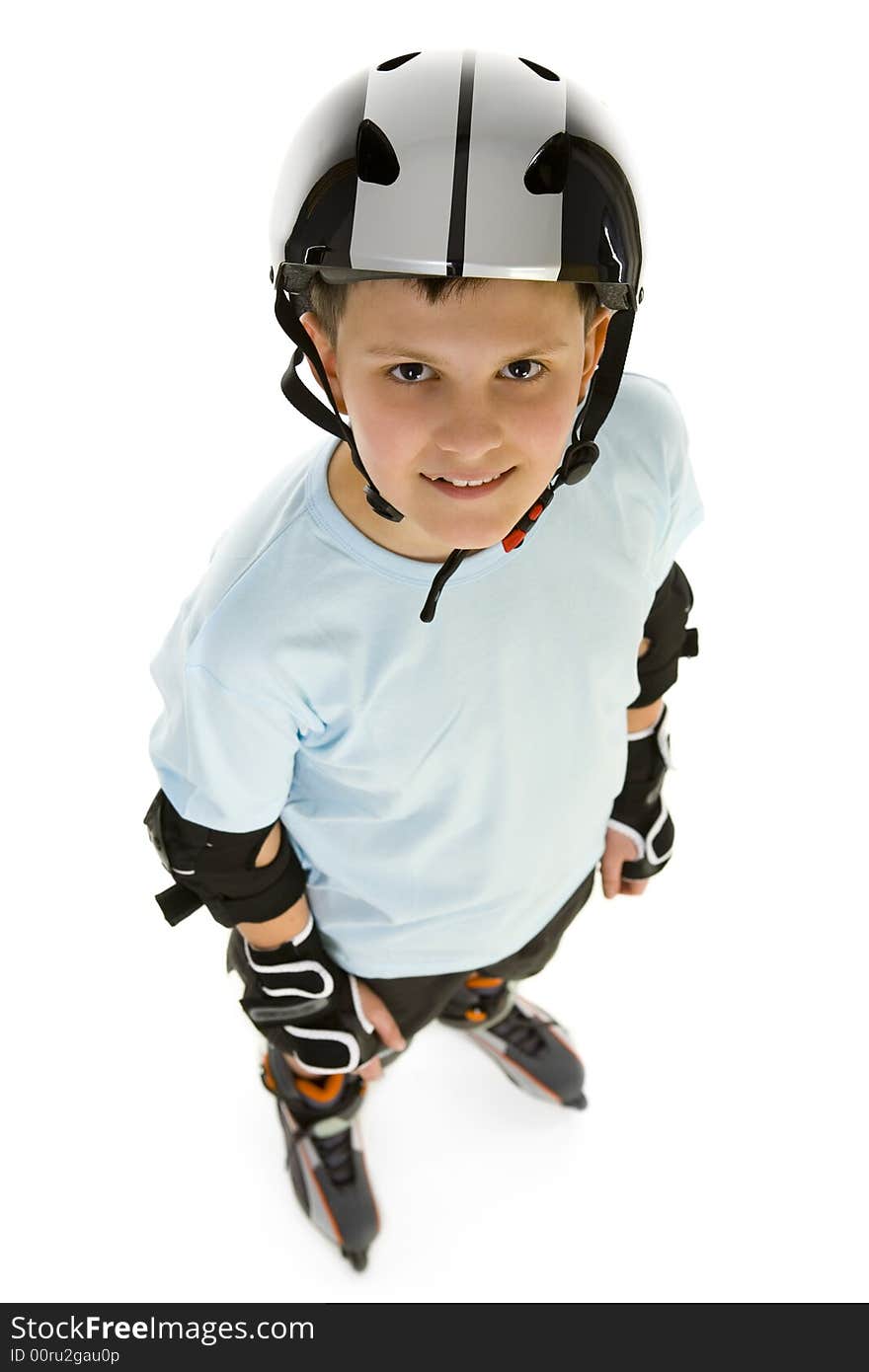 Young, happy roller boy in protection kit standing and looking at camera. High angle view. Isolated on white background. Young, happy roller boy in protection kit standing and looking at camera. High angle view. Isolated on white background.