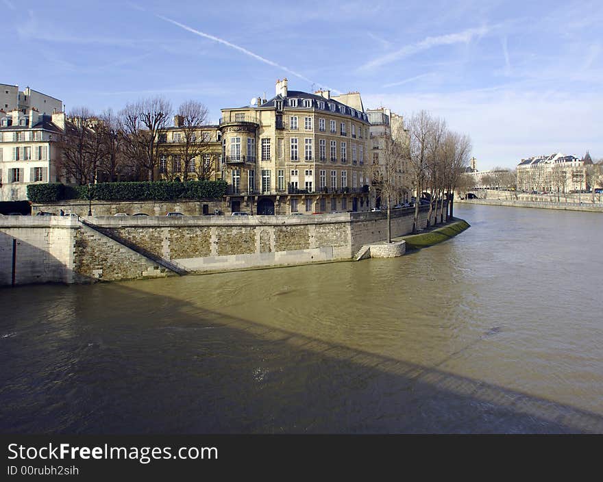 France, Paris: nice city view from the quai of the seine river; blue sky; naked trees and the river tranquility for this winter view of Paris. France, Paris: nice city view from the quai of the seine river; blue sky; naked trees and the river tranquility for this winter view of Paris