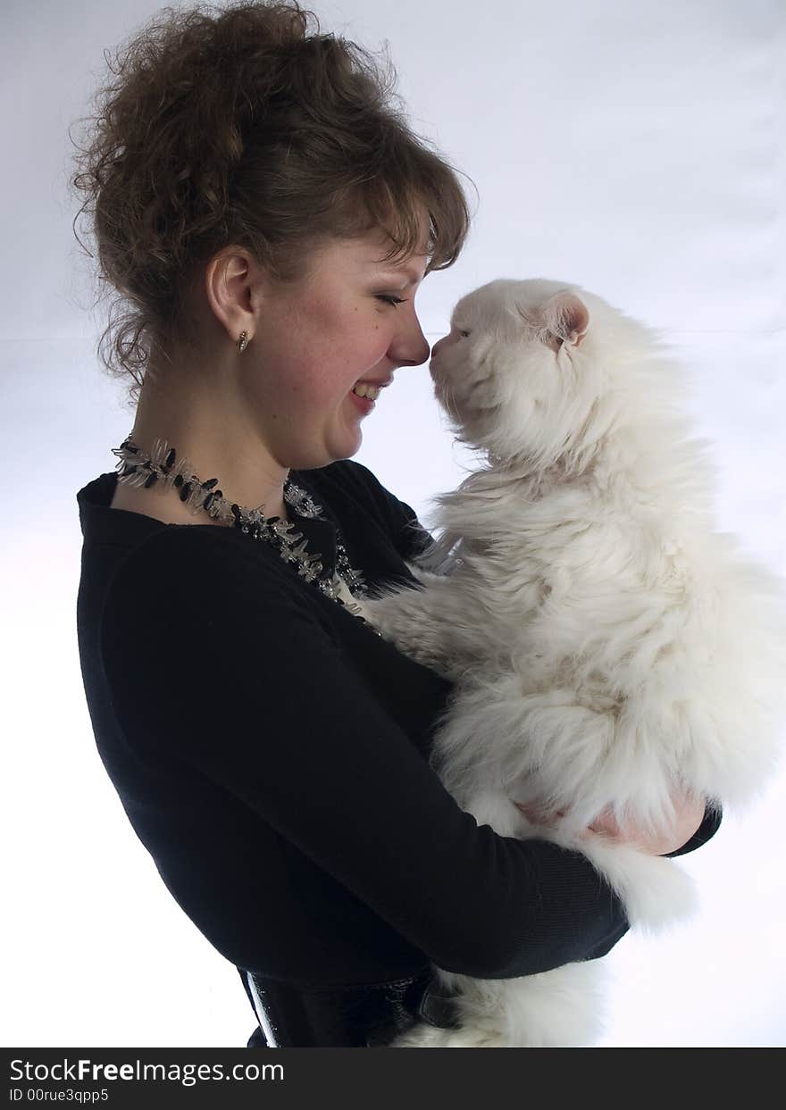 Beautiful young lady white background in glasses touching white cat nose to nose. Beautiful young lady white background in glasses touching white cat nose to nose