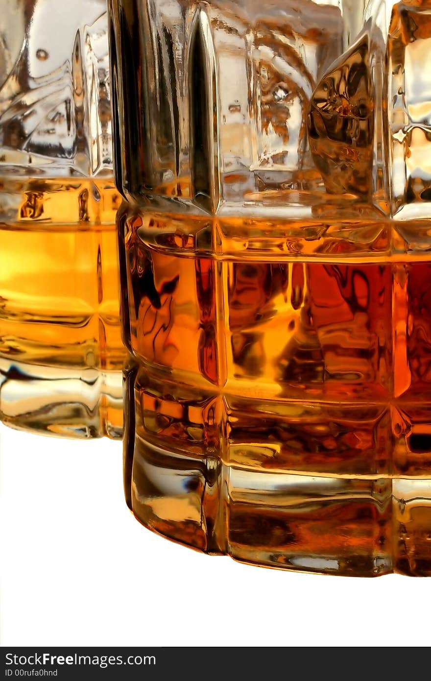 Close-up of liquor and ice in glasses on an isolated white background. Close-up of liquor and ice in glasses on an isolated white background.