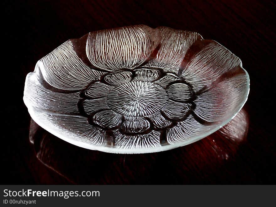 A crystal-like lotus shaped glass plate with engraved patterns, shiny and transparent. A crystal-like lotus shaped glass plate with engraved patterns, shiny and transparent.
