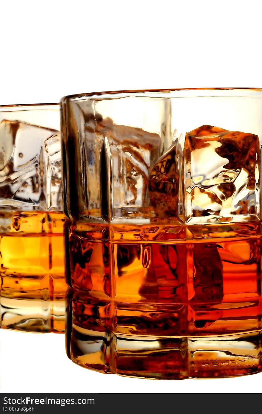 Close-up of liquor and ice in glasses on an isolated white background. Close-up of liquor and ice in glasses on an isolated white background.