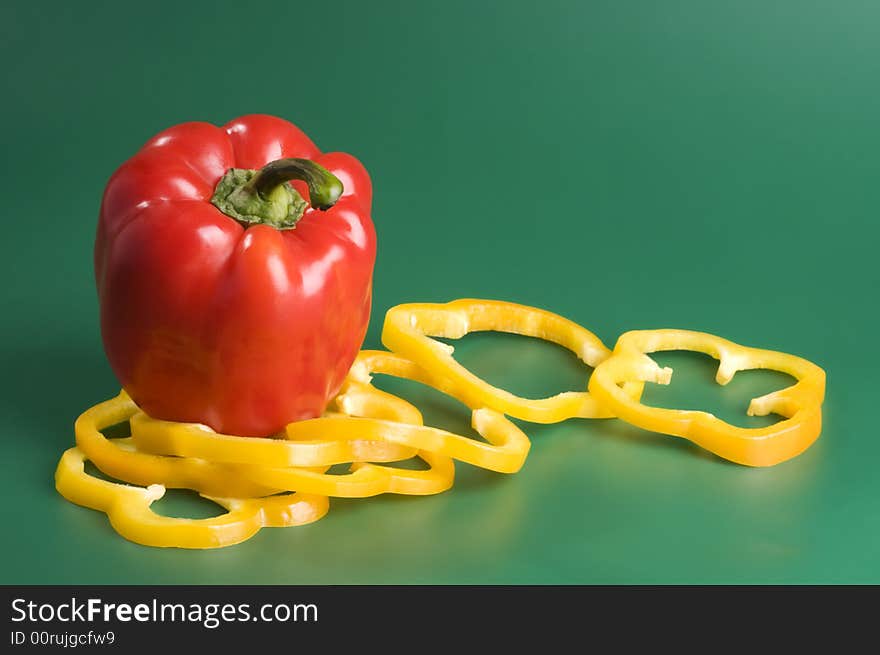 Red and yellow peppers over green background