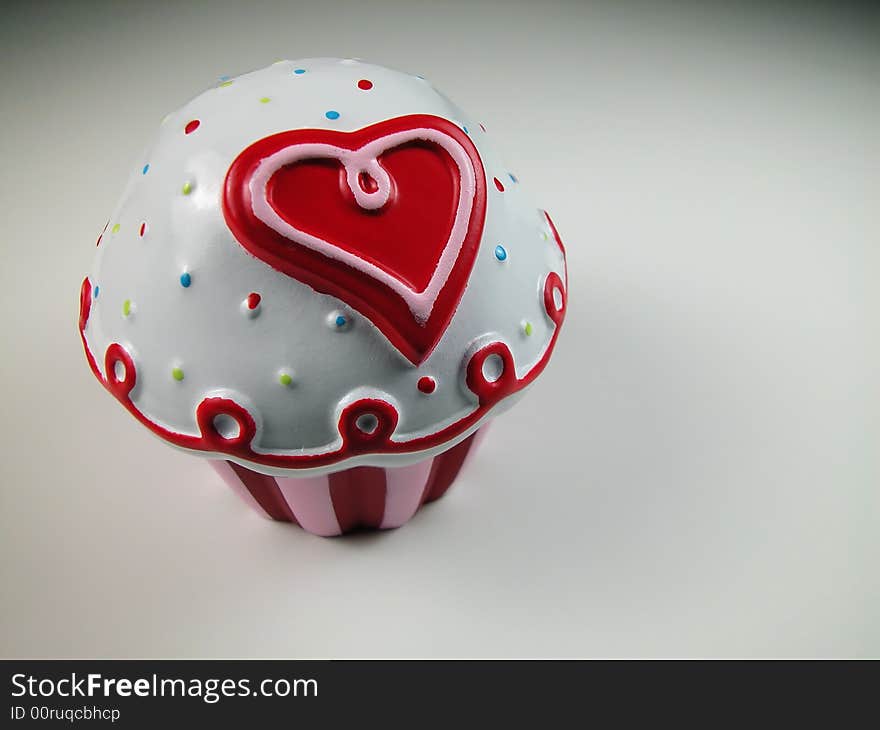 A plastic Valentines cup cake with a cartoon style heart and stripes shot with macro lens