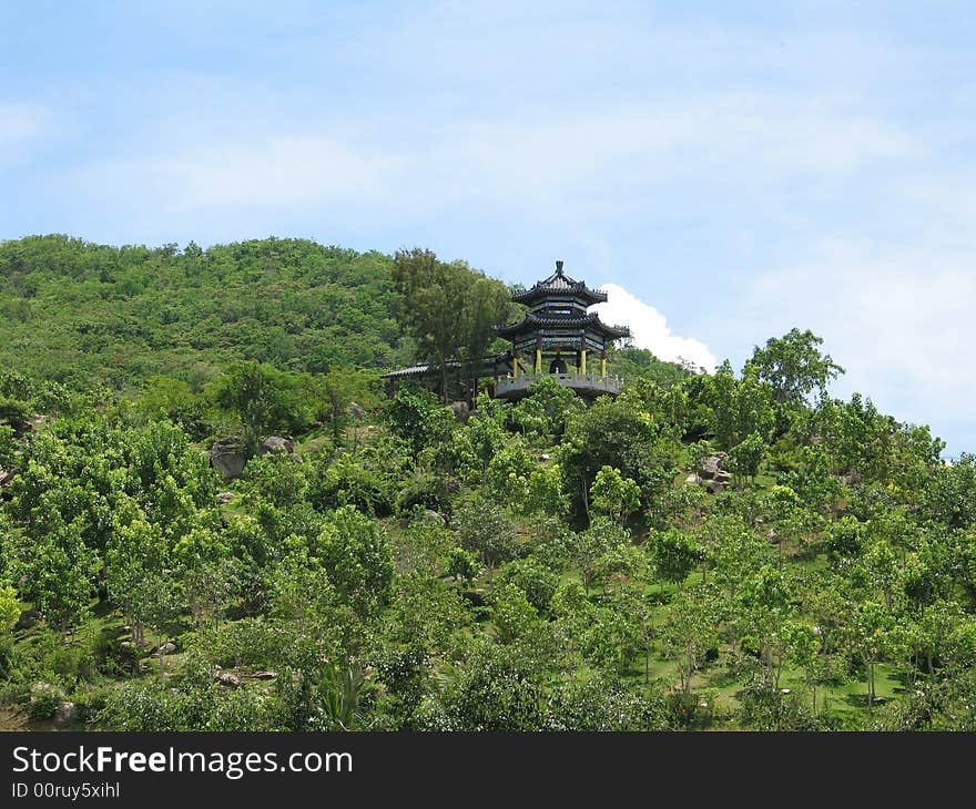 Chinese summerhouse on flank of hill in the park Nanshan on Hainan, China.