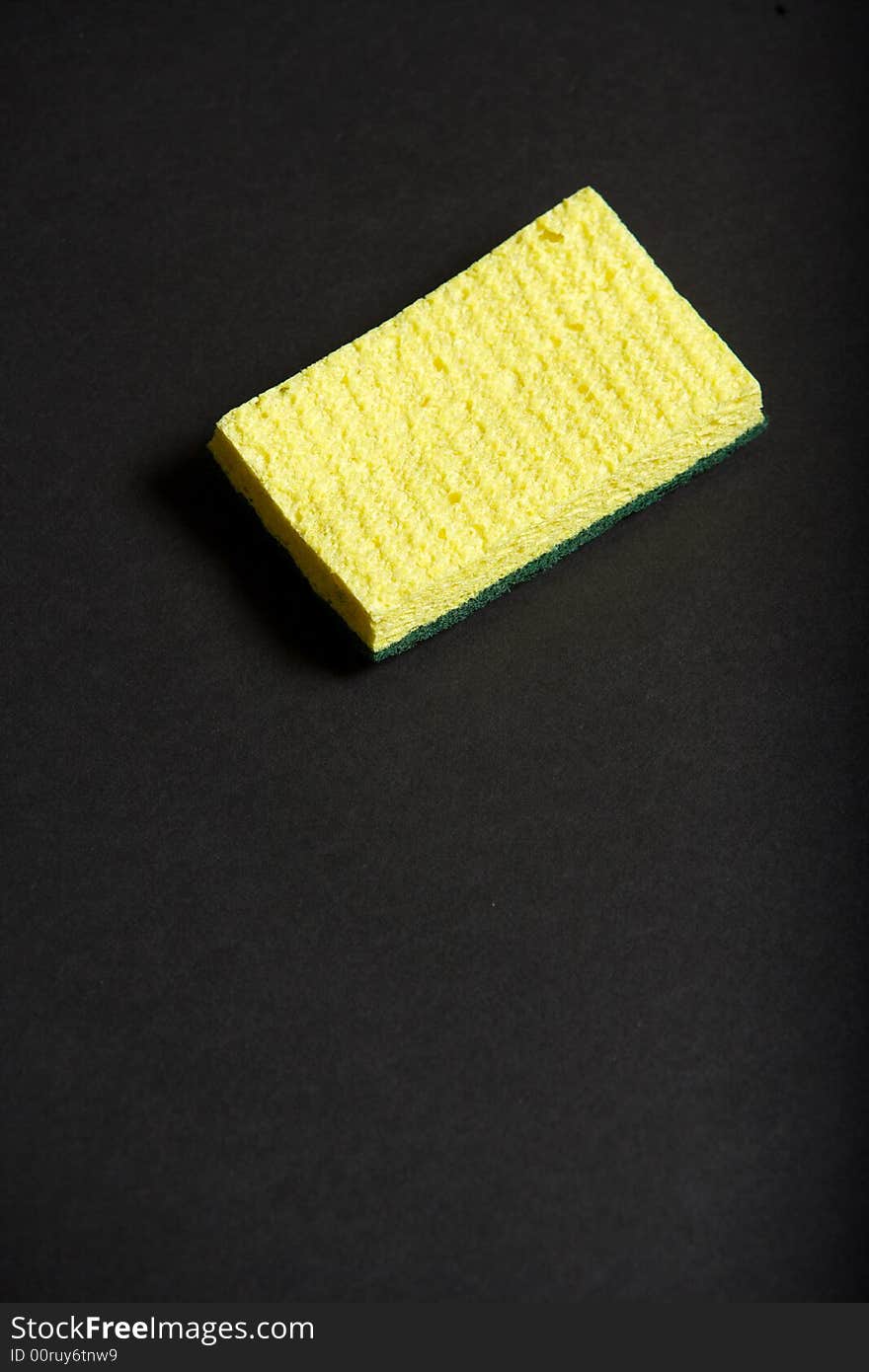 A yellow sponge on a black background