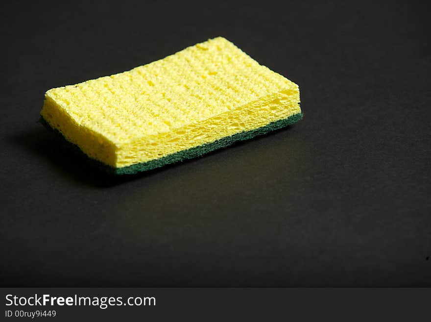 A yellow sponge on a black background