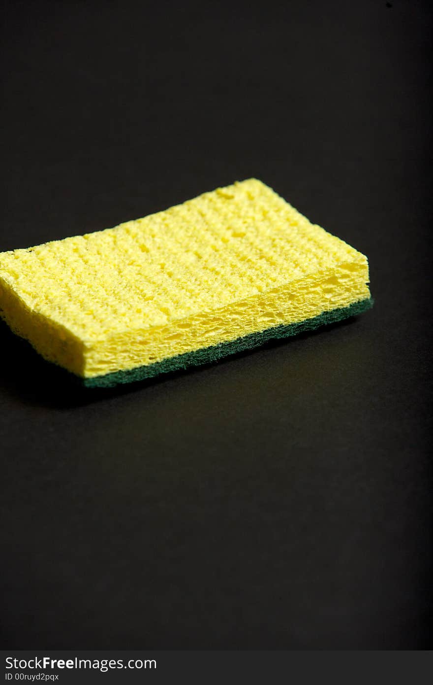 A yellow sponge on a black background