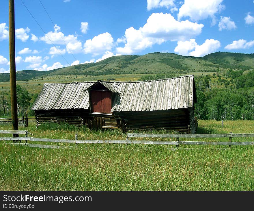 An abandoned barn alongside a dirt road.