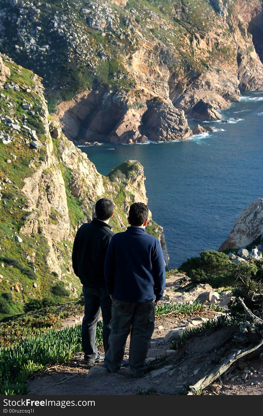 Man and boy contemplating the sea - coastline of Portugal