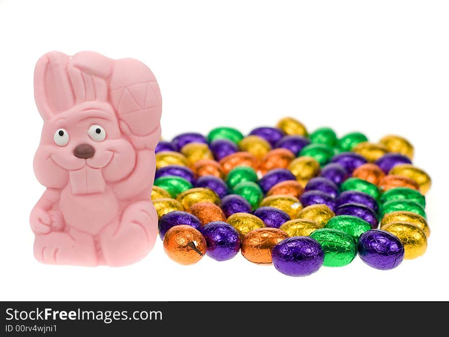 Cute easter bunny surrounded by easter eggs isolated on a white background