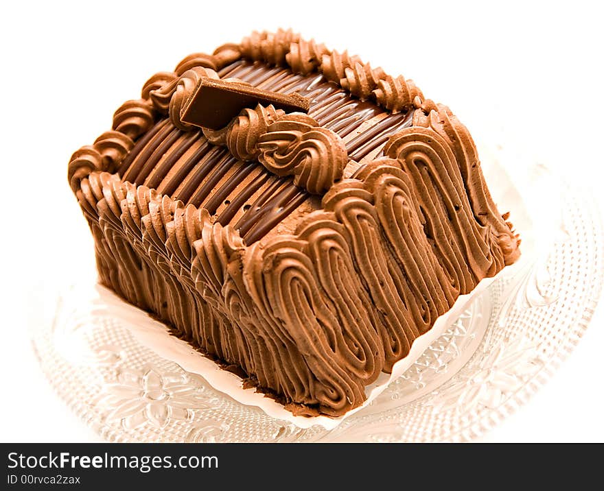 A beautifully decorated chocolate cake torte with a square of chocolate on top.