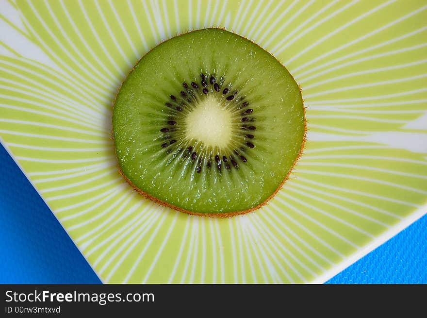 A slice of kiwi on a plate. A slice of kiwi on a plate