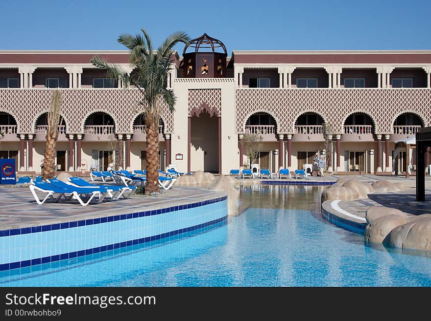 Oriental style hotel with palm tree and swiming pool