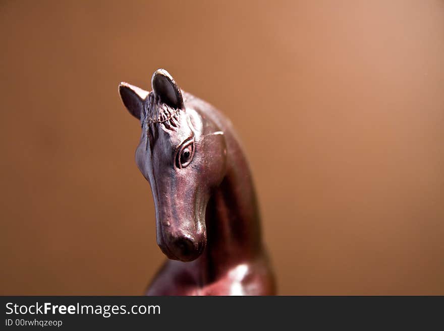 Horse head macro close up toy brown background. Horse head macro close up toy brown background