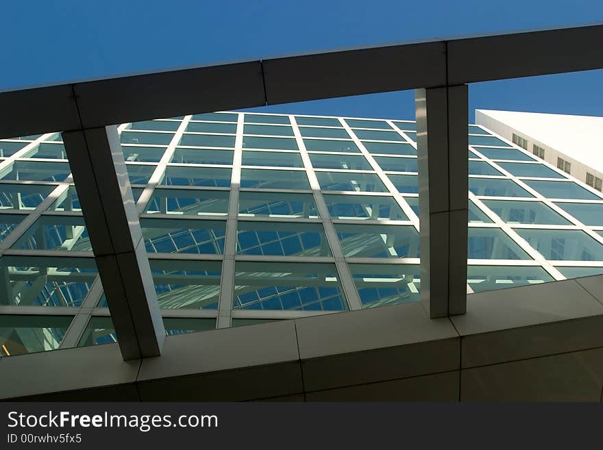 Looking through a glass wall and a glass roof towards the blue sky. Looking through a glass wall and a glass roof towards the blue sky