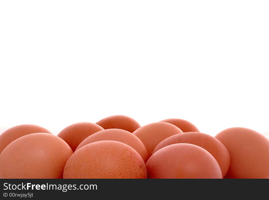 Piled brown eggs on white, with copyspace above. Piled brown eggs on white, with copyspace above