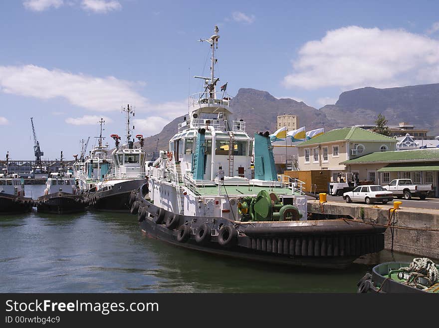 A view of tug boats in Cape Town Harbour with Table Mountain in the background. A view of tug boats in Cape Town Harbour with Table Mountain in the background