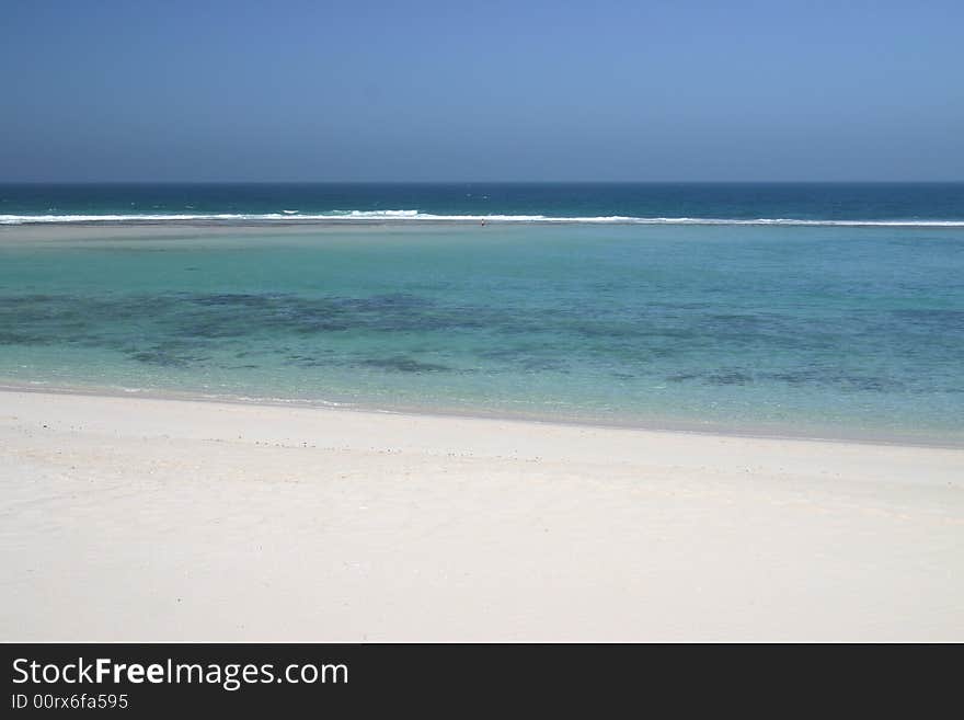 Beautiful view at sandy beach with one person standing far away in a shoal water. Australia. Beautiful view at sandy beach with one person standing far away in a shoal water. Australia.